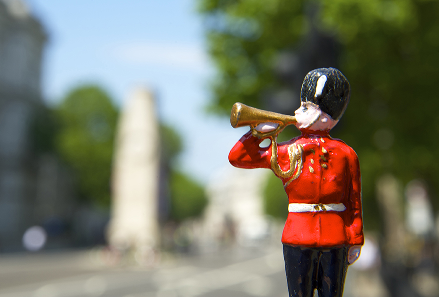 Lead toy soldier playing bugle with the Cenotaph, London, in the background